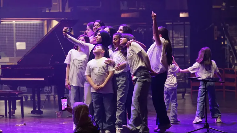 Deelnemers vieren samen feest op het podium en maken selfies
