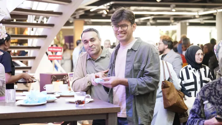 Gasten lachen naar de camera in de drukke foyer
