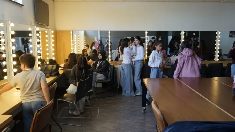 Jongeren bereiden zich voor in de kleedkamer met spiegels en lampjes voor het optreden
