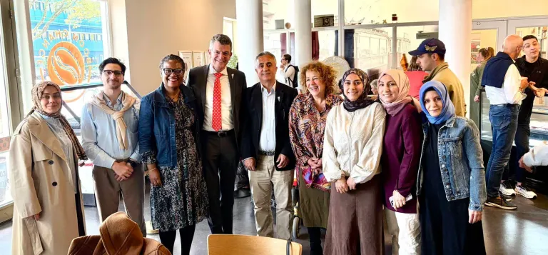 Gasten poseren samen voor een groepsfoto in een café